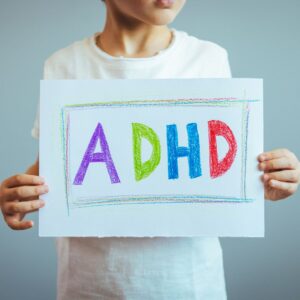 Boy holding sign saying "ADHD"