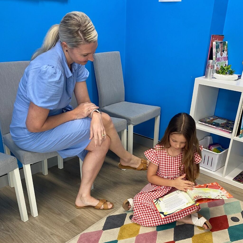 Female therapist providing speech therapy to young girl with a learning disability