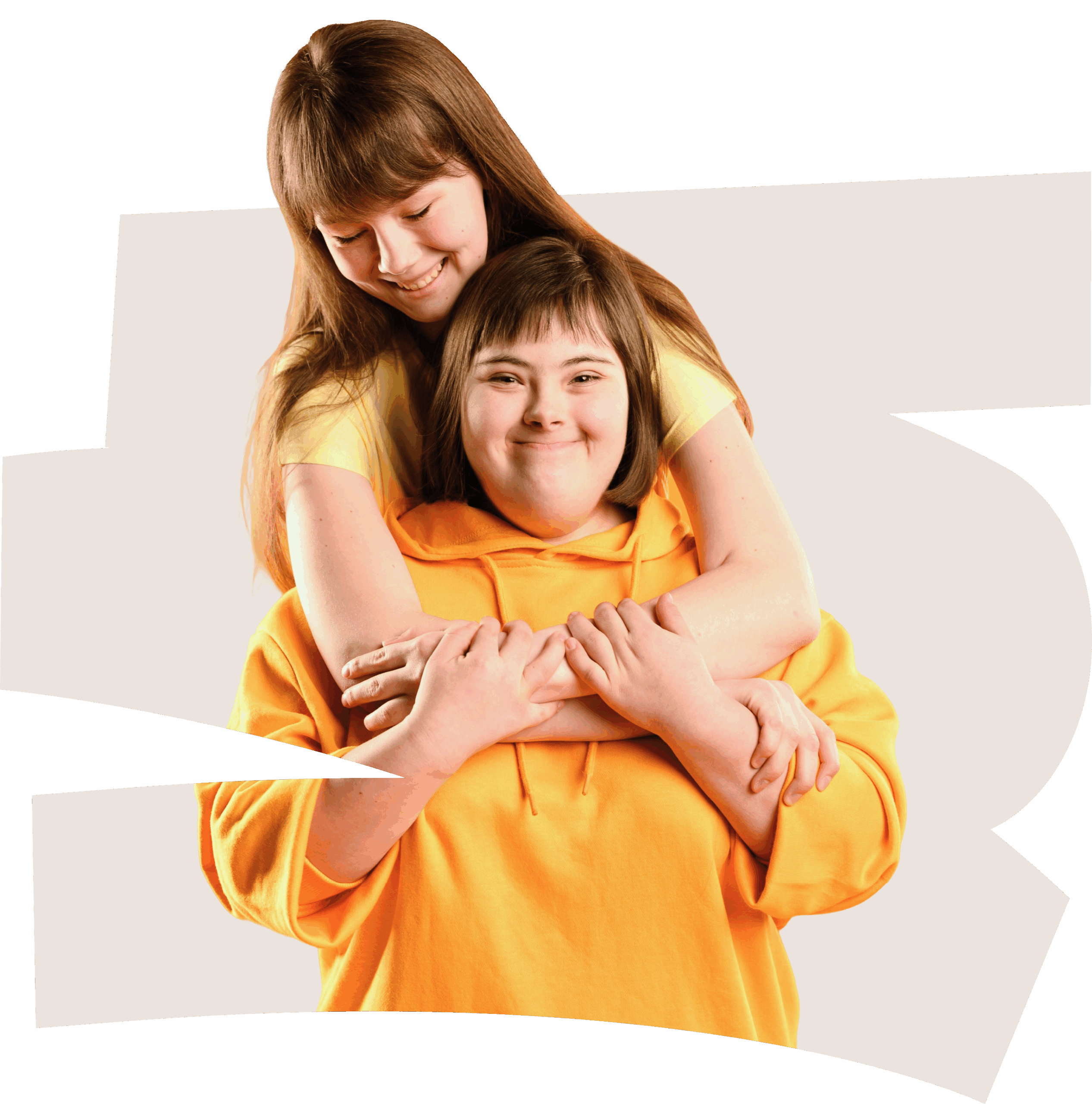 Two smiling girls, one in a yellow shirt hugging the other in an orange hoodie, stand together against a light abstract background—reflecting the joy often seen during music therapy NDIS or sessions with feeding therapists.