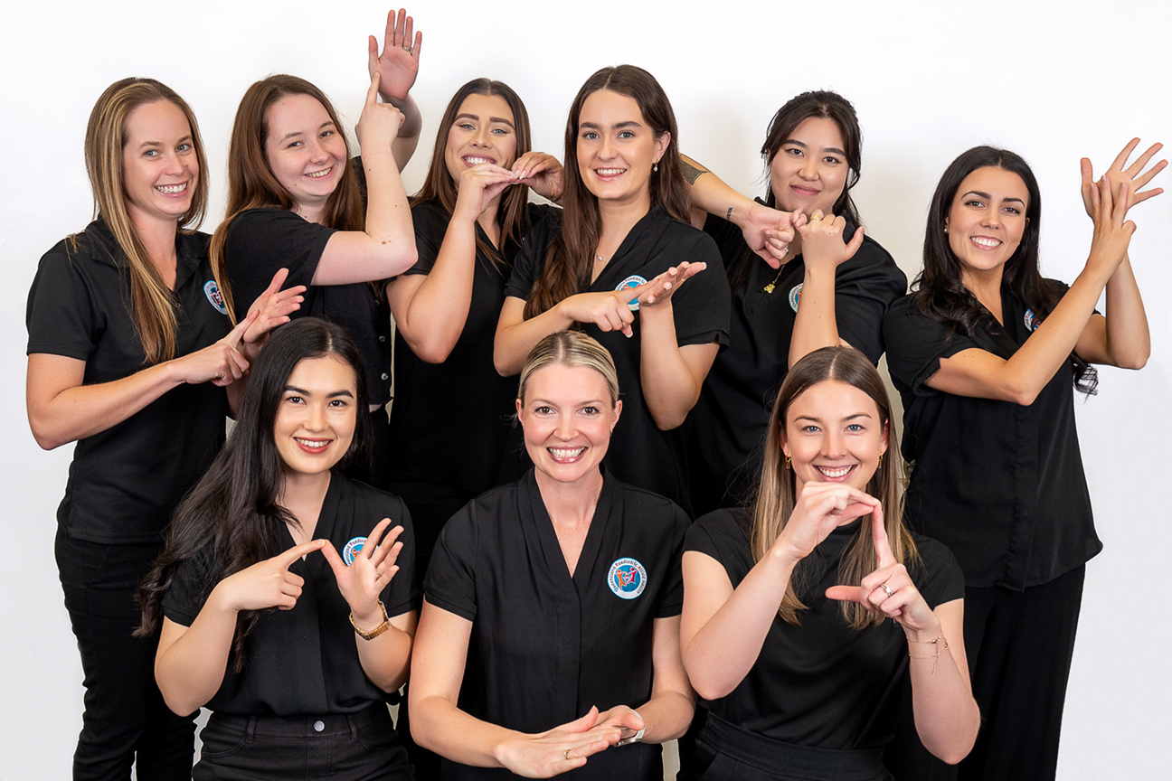 A group of women using Key Word Sign to sign their names.